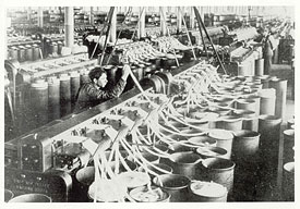 Vaste salle à l'intérieur d'une usine occupée par de la machinerie en train de carder le coton.